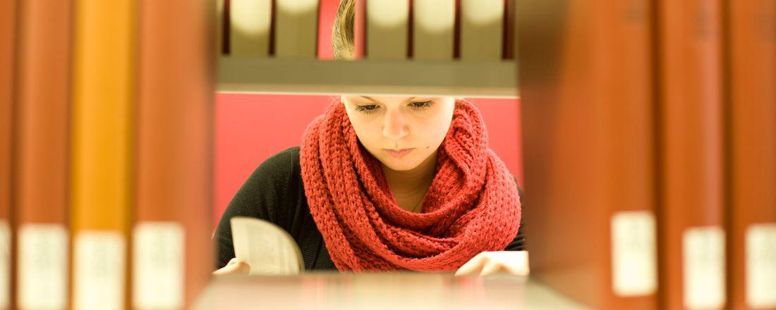 Studentin der Universität Bayreuth liest ein Buch in der Zentralen Universitätsbibliothek.